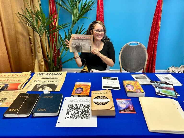 GAPAS history exhibit with a woman displaying The Message newspaper